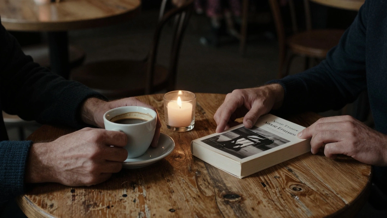 Two hands rest on a wooden table beside a book and coffee cup in a dim, intimate café.